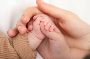 Anne, küçük bebeği evde, yatağında, yakın plan.