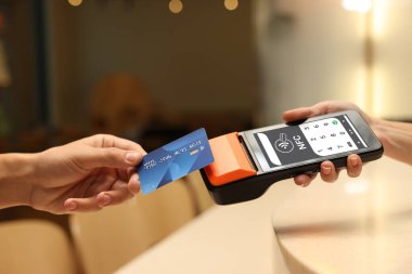 NFC sistemli ödeme terminali. Müşteri içerideki servis için kredi kartını kullanıyor, kapatıyor.
