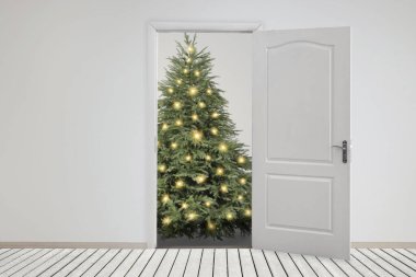 Kapının önünde şenlik ışıkları olan güzel bir Noel ağacı. Tatil sezonu
