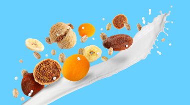 Süt sıçraması, yulaf ezmesi ve açık mavi arka planda kurutulmuş meyve. Pankart tasarımı