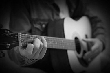 Gitar çalan adam, yakın plan. Siyah ve beyaz etkisi