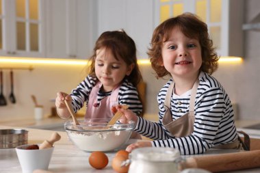 Yemek tarifi. Sevimli çocuklar mutfaktaki masada kurabiye için para kazanıyor.