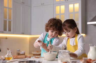 Yemek tarifi. Sevimli çocuklar mutfaktaki masada kurabiye için para kazanıyorlar. Metin için boşluk