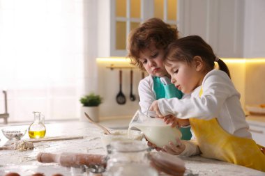 Yemek tarifi. Sevimli çocuklar mutfaktaki masada kurabiye için para kazanıyorlar. Metin için boşluk