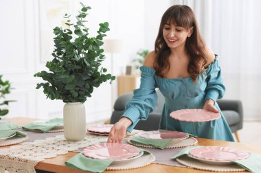 Akşam yemeği için masa hazırlayan kadın.