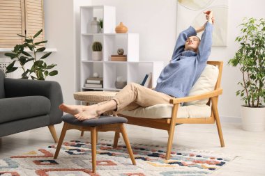 Evdeki rahat koltukta dinlenen güzel kadın.