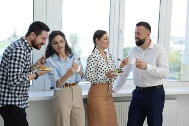 Yemek ve içeceklerle iş arkadaşları öğle arasında ofiste pencere kenarında.