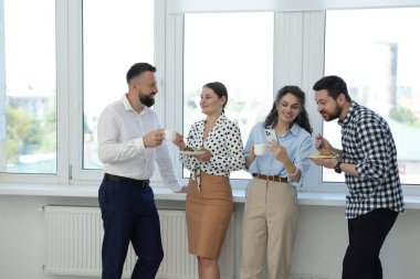 Yemek ve içeceklerle iş arkadaşları öğle arasında ofiste pencere kenarında.