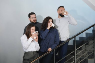 Mesai arkadaşları kahve molası sırasında ofislerinde kahve içerler.