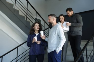 Mesai arkadaşları kahve molası sırasında ofislerinde kahve içerler.