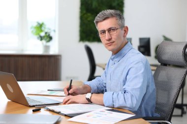 Ofiste evrak işleriyle uğraşan işadamının portresi