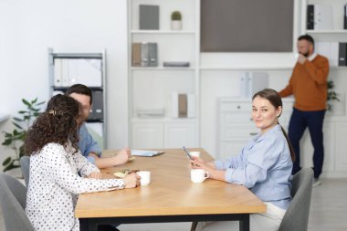 İş arkadaşları öğle arasında yemek yiyor.