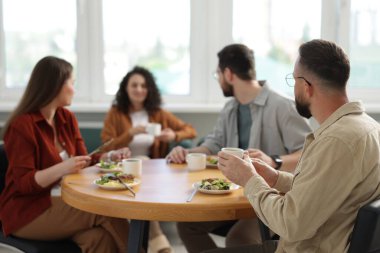 İş arkadaşları öğle arasında ofiste sohbet ediyorlar.