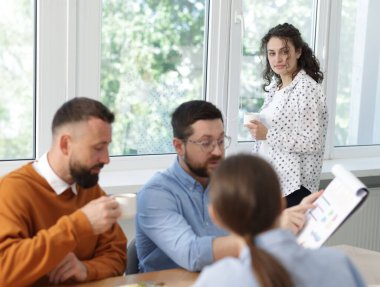 İş arkadaşları yemek yiyor ve ofiste öğle arasında iş tartışıyorlar.