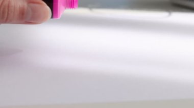 Beyaz kağıda pembe akrilik boya sıkan kadın, yakın plan.
