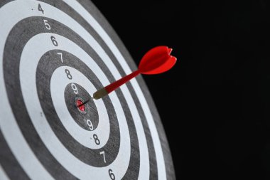 Hedef alınıyor. Siyah arkaplanda ok olan dart tahtası, yakın plan