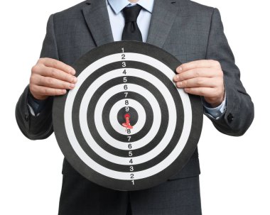 Hedef alınıyor. Beyaz arka planda dart tahtası olan adam, yakın plan.