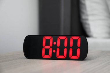 Dijital alarm saat 8 'de kapalı bir masada.