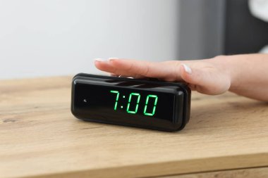 Kadın, başucundaki masanın dijital alarmını kapatıyor.