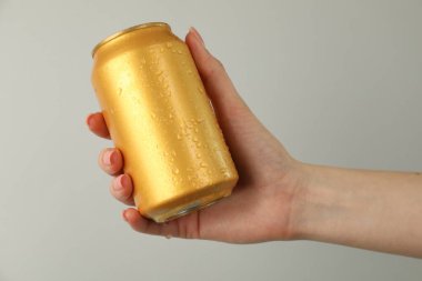 Açık gri arka planda teneke kutusu olan kadın, yakın plan.