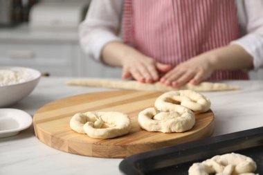 Mutfaktaki masada simit şekillendiren kadın, yakın plan.