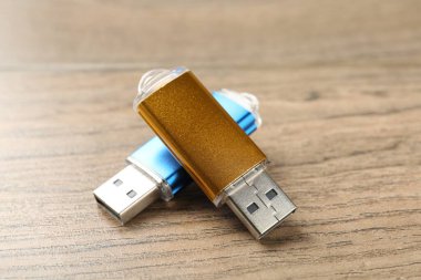 Ahşap arka planda iki flaş bellek, yakın plan.