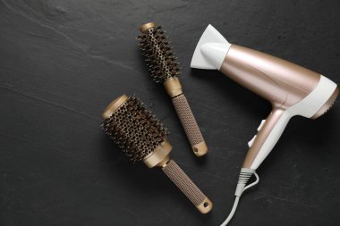Yuvarlak fırçalar ve kurutma makinesi siyah masada, düz yerde. Metin için boşluk