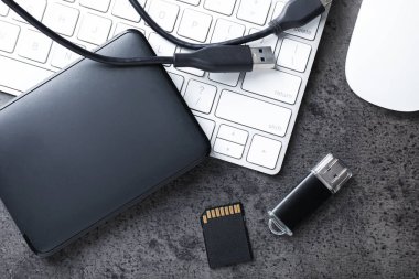 SD hafıza kartı, USB flash disk, kablo ve klavyeli sabit disk koyu gri tablo, düz yatıyordu