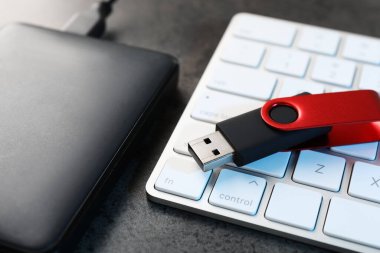 USB flaş bellek, sabit disk sürücü ve klavye koyu gri tabloda, yakın plan