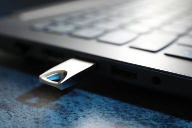 USB flaş bellek koyu gri masadaki dizüstü bilgisayara bağlandı.
