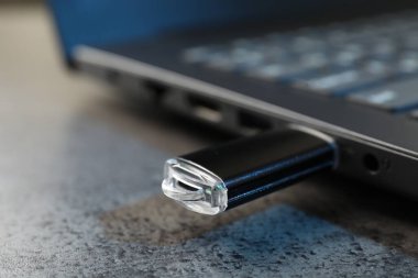 USB flaş bellek koyu gri masadaki dizüstü bilgisayara bağlandı.