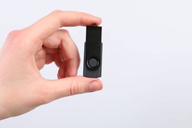 Açık gri arka planda modern flash diski olan adam, yakın plan. Metin için boşluk