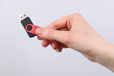 Açık gri arka planda modern flash diski olan adam, yakın plan.