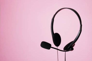 Pembe arka planda mikrofonlu kulaklık, metin için boşluk