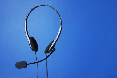 Mavi arkaplanda mikrofonlu kulaklık, metin için boşluk