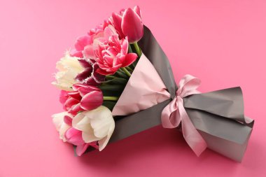 Bouquet of beautiful tulips on pink background