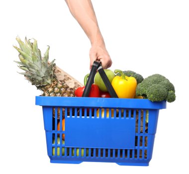 Beyaz arka planda farklı ürünleri olan alışveriş sepeti tutan adam, yakın plan.