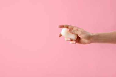 Açık pembe arka planda sabun çubuğu olan kadın, yakın plan. Metin için boşluk