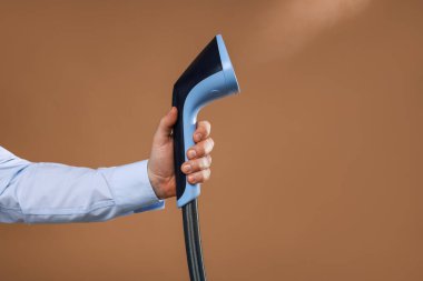 Kahverengi arka planda vapuru olan adam, yakın plan.