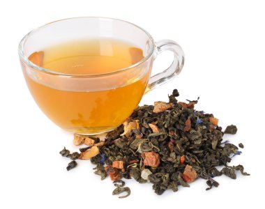 Cam fincanda nefis bitki çayı ve beyaz yaprakların üzerinde kuru yapraklar.