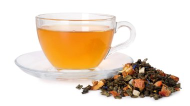 Cam fincanda nefis bitki çayı ve beyaz yaprakların üzerinde kuru yapraklar.