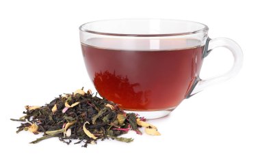 Cam fincanda nefis bitki çayı ve beyaz yaprakların üzerinde kuru yapraklar.