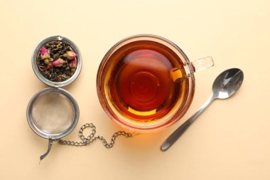 Cam fincanda nefis bitki çayı, kuru yapraklar ve bej arka planda kaşık, düz uzanma