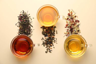 Bej arka planda taze demlenmiş çaylar ve kuru yapraklar.