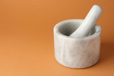 Açık kahverengi arka planda mermer harç ve tokmak, yakın plan. Metin için boşluk