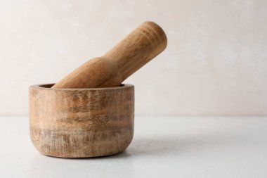 Tahta havan ve tokmak beyaz masada, yakın plan. Metin için boşluk