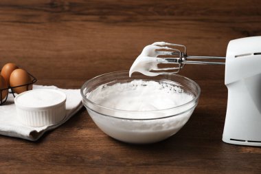 Çırpılmış çırpılmış çırpılmış krema ve çırpılmış krema ile ahşap masada, yakın plan.