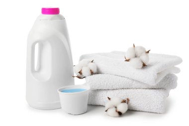 Bir şişe yumuşatıcı, pamuk çiçekleri ve beyaz üzerine izole edilmiş temiz havlular.