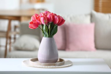 Beyaz masadaki vazodaki güzel laleler