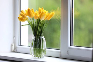 Pencere pervazında vazodaki güzel laleler